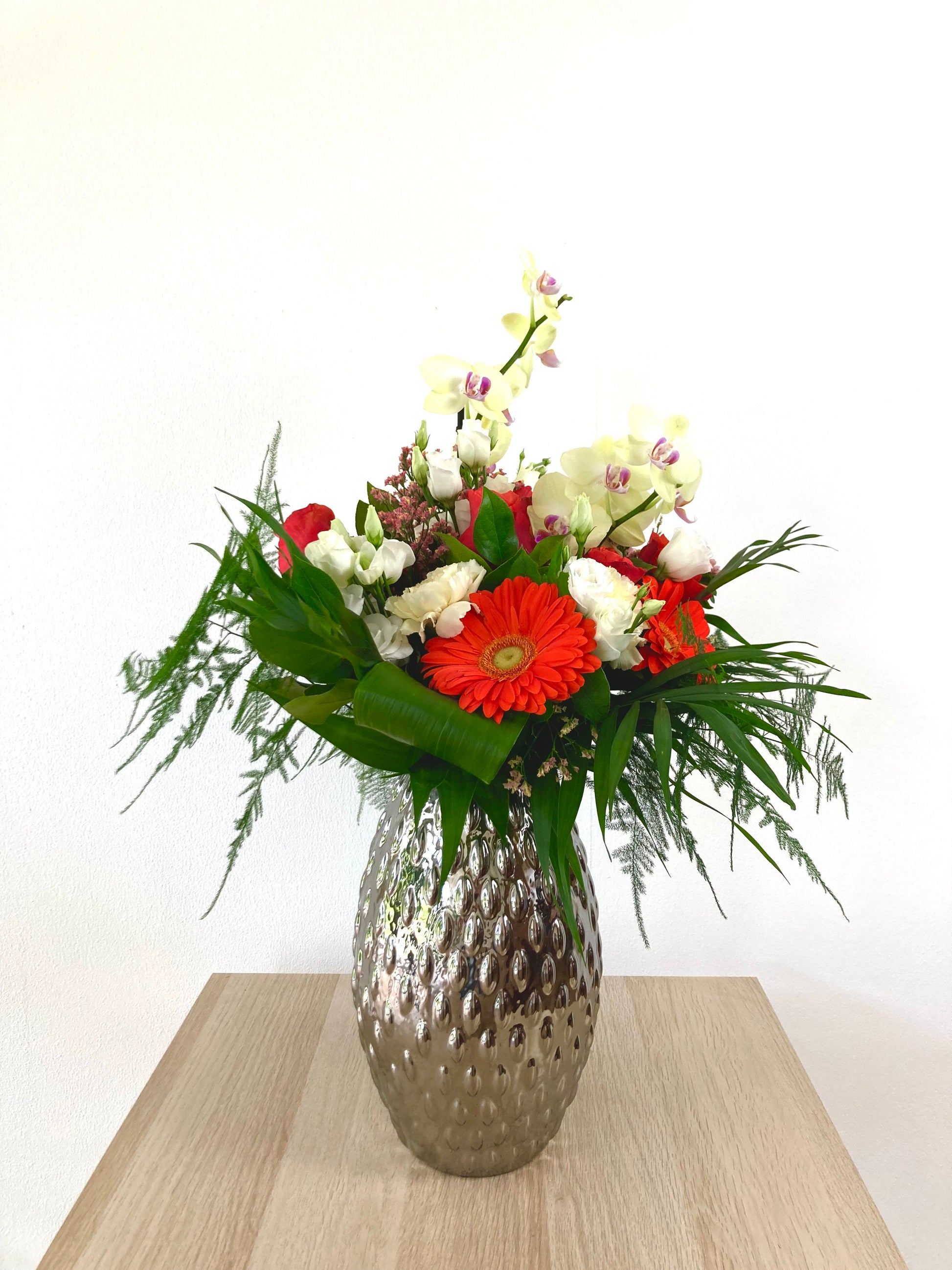 Bouquet avec branches d'orchidées dans un vase sur une table